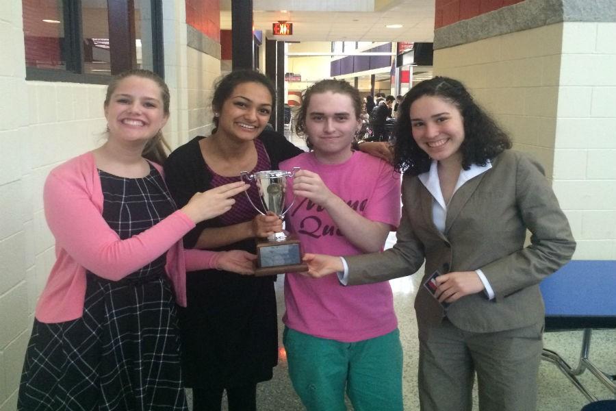 Forensics Speech officers hold up a symbol of their hard-earned victory.