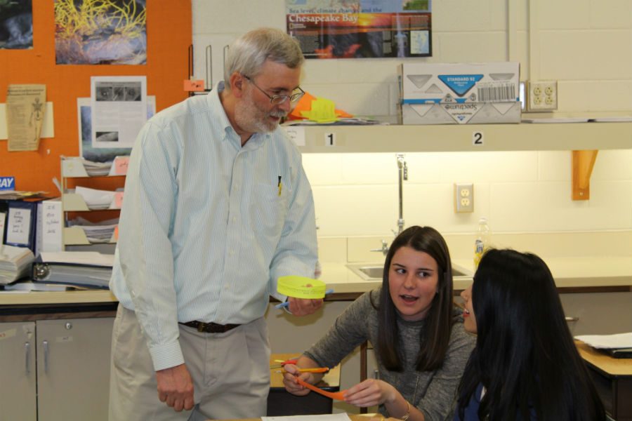 Mr. Pettis helps students Isobel Harrison and Mukti Patel with their assignment. 