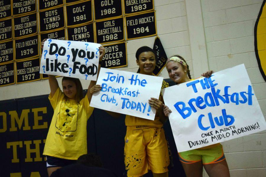 The Breakfast Club members pose with their signs to convince other people to join the club.