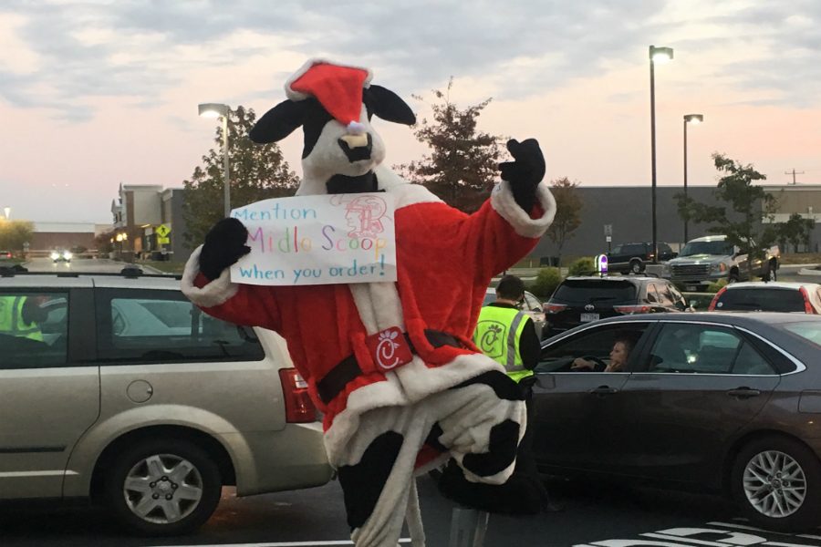 The cow helps the students by holding the sign!