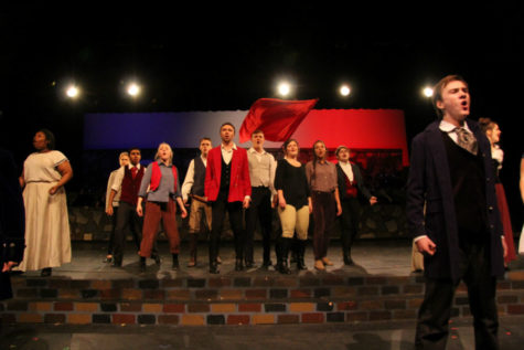 Carter Seaborn, as Enjolras, leads the cast during One Day More in Les Mis.