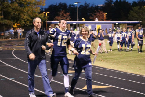 Senior quarterback Kyle Daniluk is escorted by his parents on Senior Night.