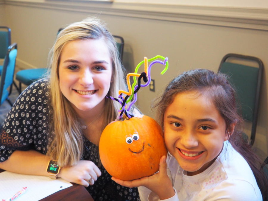 Kenley Elliott and her Homework Helpers student share enthusiasm when showing off their pumpkin.  