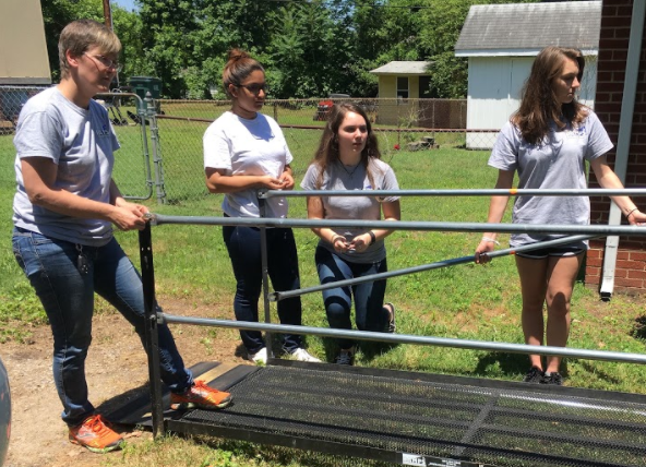 Students Carrie Rowley, Rachel Edwards, and now-high school graduate Mishaal Gilani assemble a ramp for RAMPS, a nonprofit organization that creates ramps for people with disabilities.