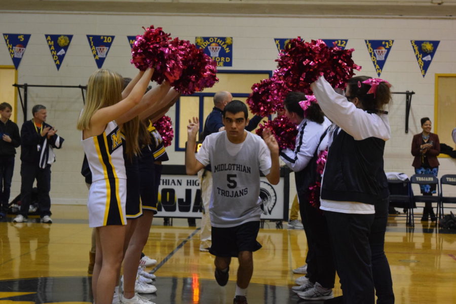 Midlo players run through a tunnel of Midlo cheerleaders before the Midlo v. Manchester Medford basketball game, held at Midlothian High School.
