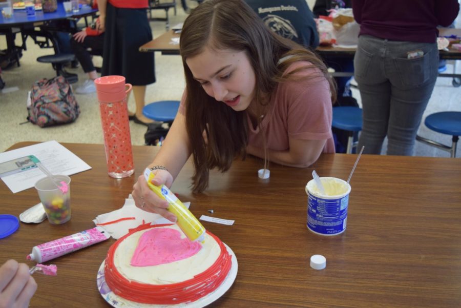 Sophomore Sarah Nugent works on her Valentines themed cake at the Latin Club Cake Decorating Competition.