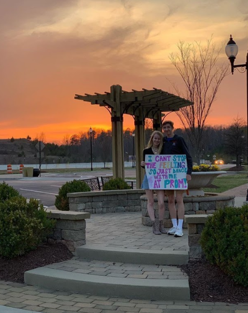Senior Jack Steele promposes to junior Olivia Clarke with a poster in the sunset. 