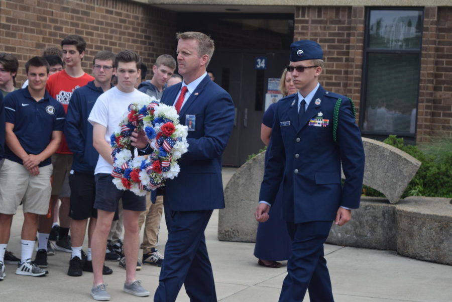 On Tuesday, May 28, 2019, Midlothian High School paid tribute to those who have made the ultimate sacrifice for their service by laying a wreath on the war memorial honoring Major Charles Ransom. Principal Shawn Abel, joined by freshman Connor Long, prepares to place the wreath on the war memorial.