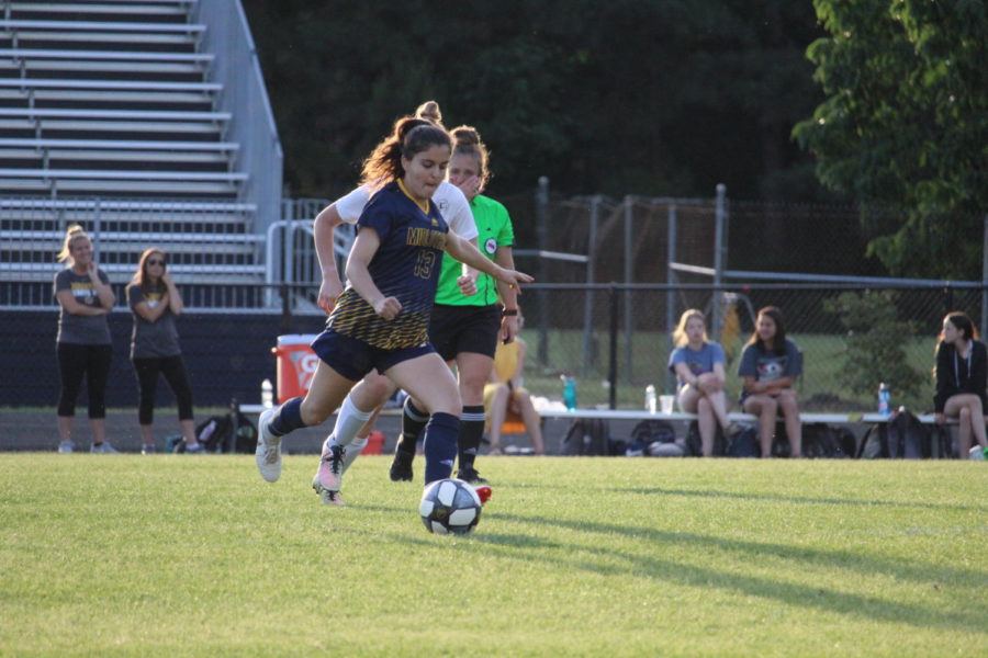 Anna Basir plays a pass past a Louisa defender.