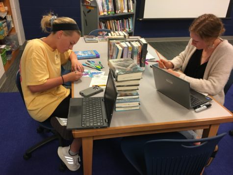 Lauren Lingle and Maggie McDermott create Blackout Poetry in Mrs. Tullys AP Lit class.