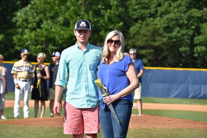 Baseball manager Grayson Sommerdahl, escorted by his mother, receives recognition on 2019 Baseball Senior Night.