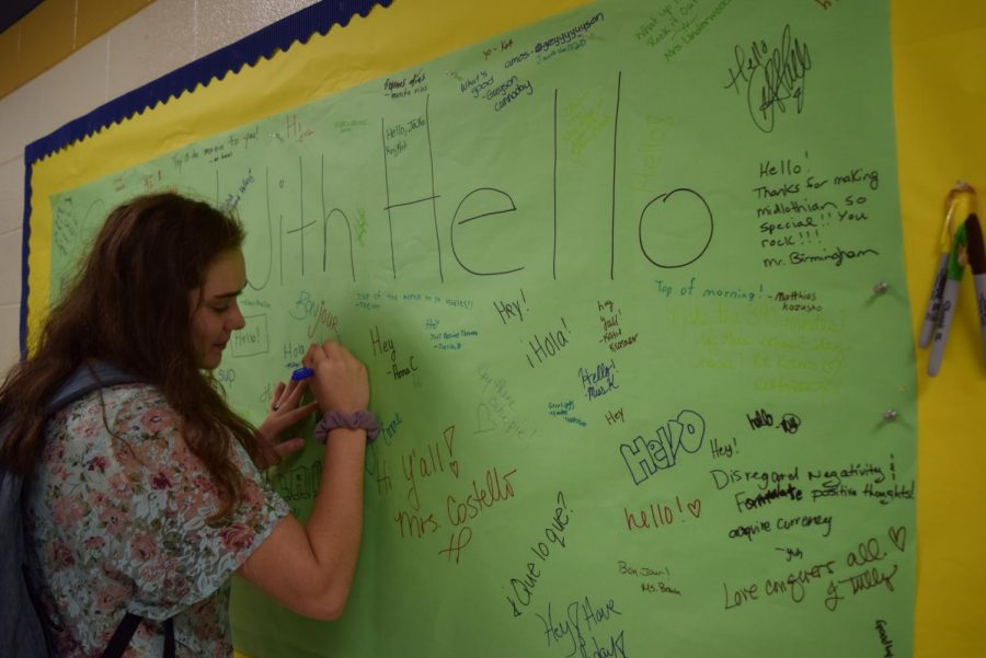 Olivia Eggleston writes her name on the Start With Hello Banner.