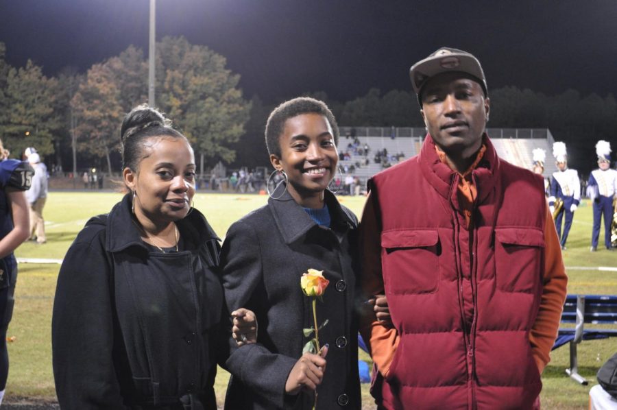 Cameron Lee stands with her parents on Senior Night.