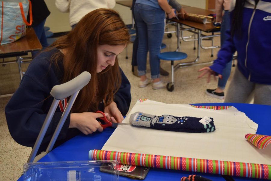 Senior Anna Basir focuses on wrapping  socks at the Spirit Club 2019 Wrapping Party.