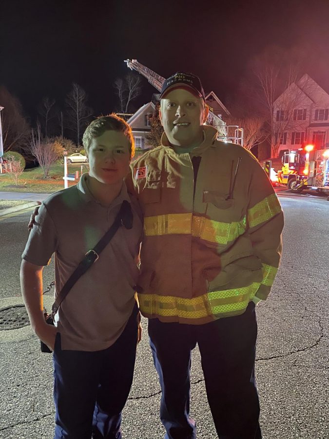 Chrisitan Davies stands with Lt Jason Elmore, the Public Information Officer for the Chesterfield County Fire Department, after a local fire had been extinguished.