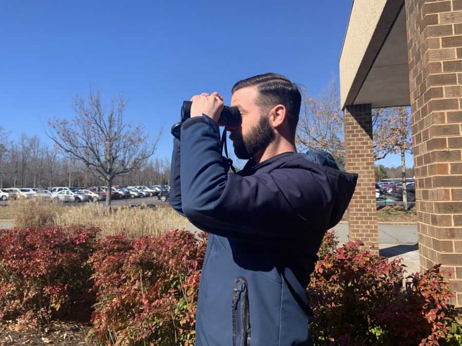 Mr. Zachary Woolard spends his lunch period watching birds outside of the Midlo Library.