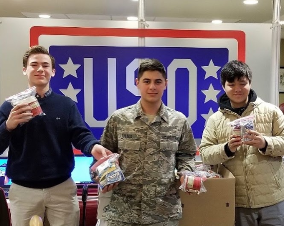 Freshmen Officers Brennan Lane and Arron Lui deliver donations to the USO.