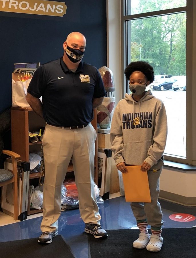 Tanaiya Turner happily accepts her Student of the Month award from Assistant Principal Mr. Steven Lagow.