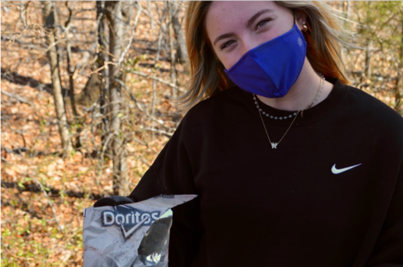 Sophomore Kate Grillot shows off a discolored Doritos bag while cleaning the school on beautification day.