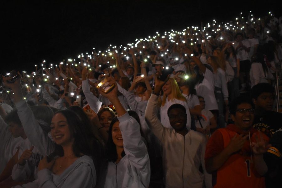 Midlo students wave their phones and sing to the beat of Sweet Caroline at their homecoming game against Cosby.