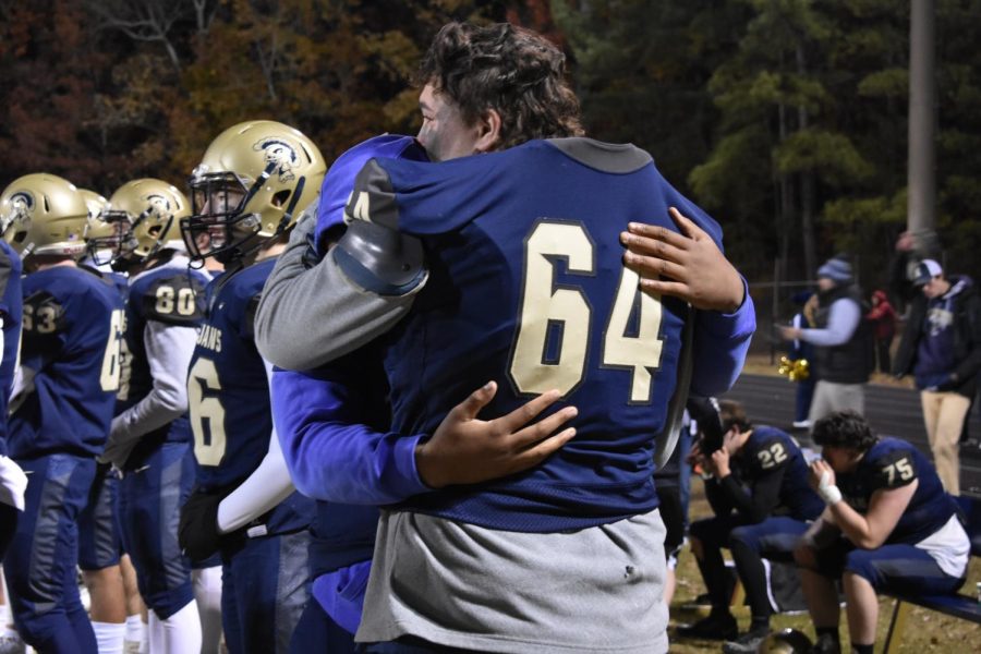 The Trojan football players embrace each other after the game as their season comes to a close.
