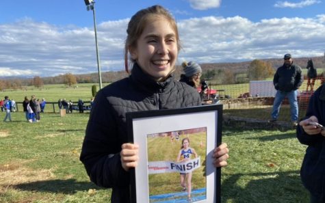Gabriella Garcia, the 2021 VHSL Class 5A State Cross Country Champion, receives a prized memento for her hard work.