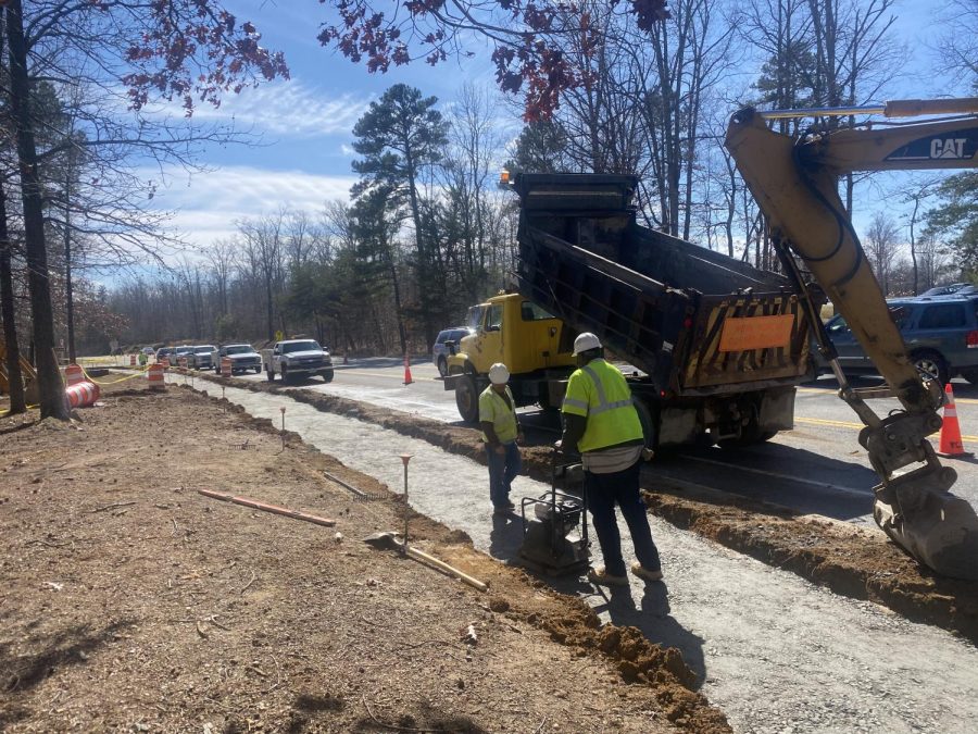 VDOT crews work to install a new sidewalk alongside Charter Colony in front of the student parking lot.