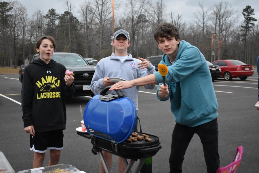 Students use the grill to cook breakfast at the tailgate.