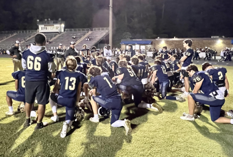 Midlos varsity football team kneels down to discuss their remarkable win over the Monacan Chiefs