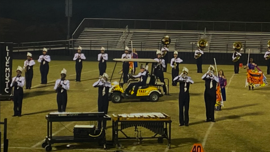 Band member from North Sutherland performs his clarinet solo from the back of a decorated golf cart.