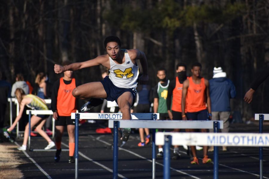 2021 Member Armani Hinman hurdles over multiple obstacles.
