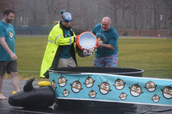 Officer McDonough and Mr. Lagow pour ice into the plunge tubs.