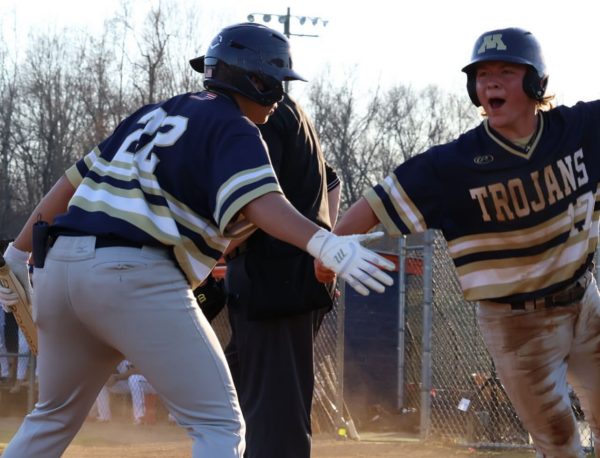 Junior Coleson Caffall celebrates with his teammate after earning a run against the Manchester Lancers,
