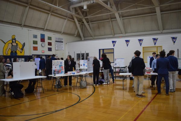 Students promote their legislation by presenting a poster board and handing out food.