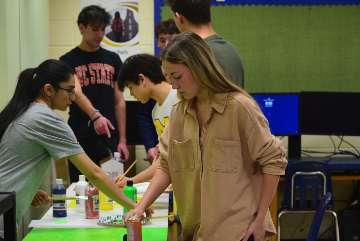 Students in S.T.E.M Club paint their board that will be displayed in the Open Commons. 