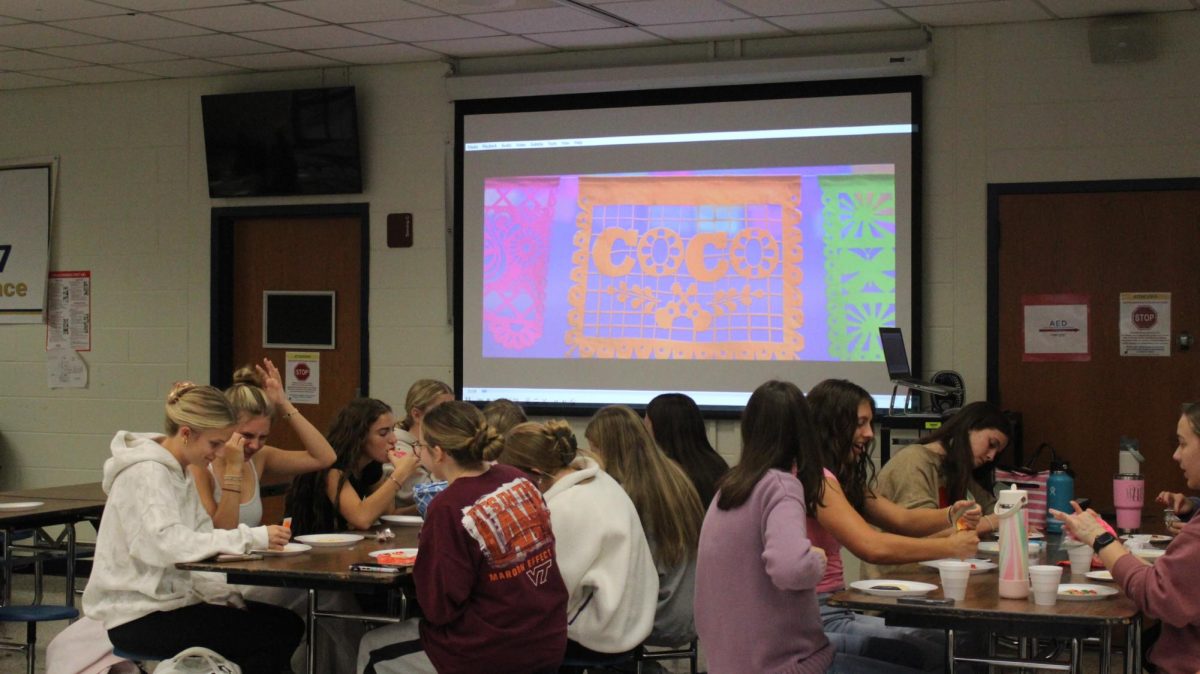 Spanish Club students decorate cookies while Coco plays in the background.